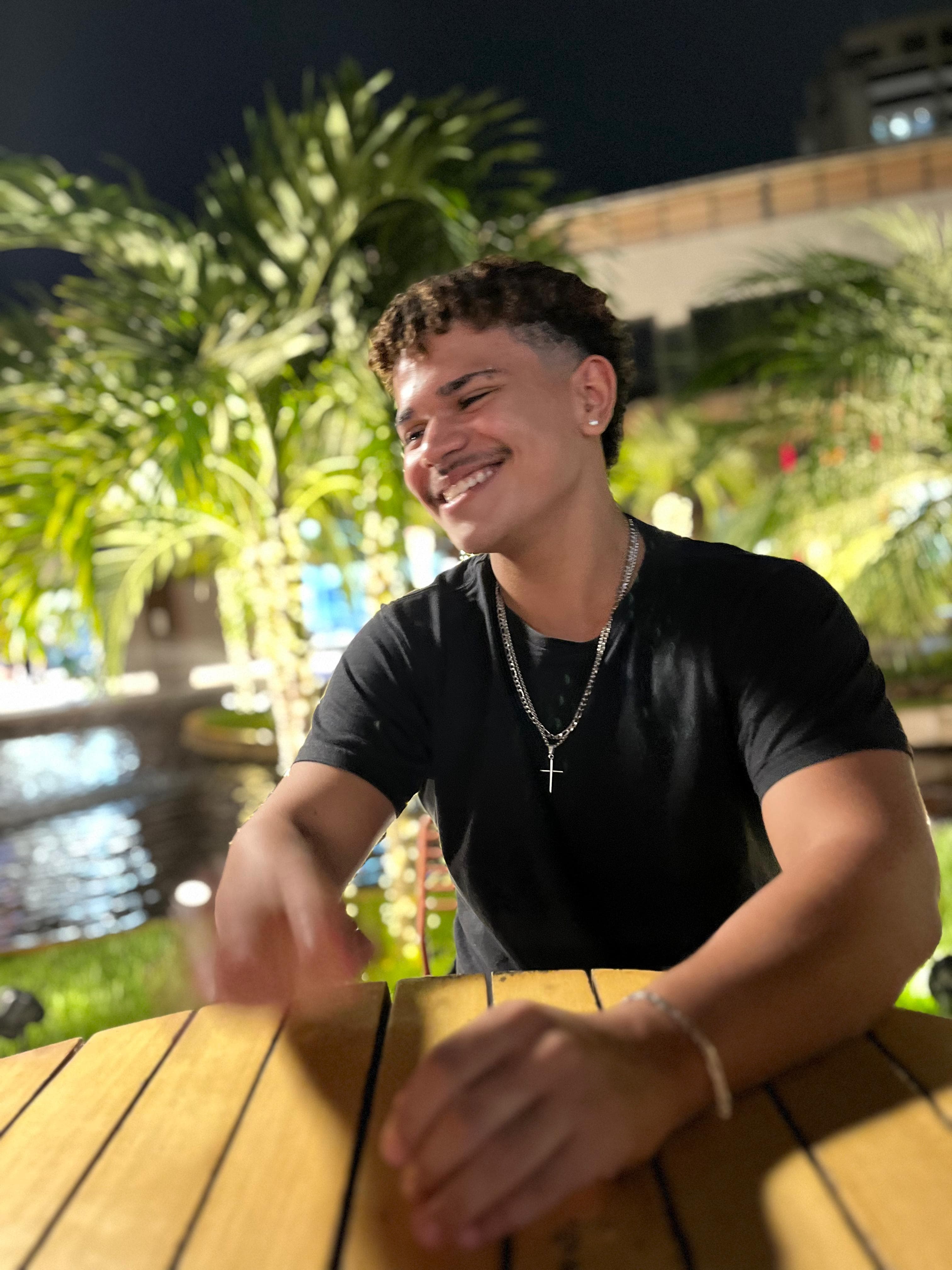 Foto de Miguel Angelo sorrindo, de camiseta preta